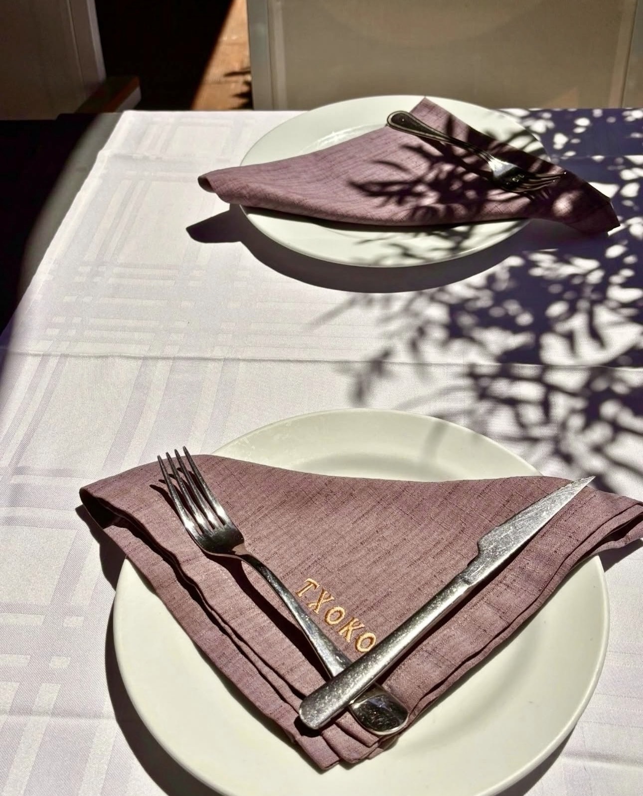 Mesa preparada en El Txoko, servilleta bordada con luz de sol